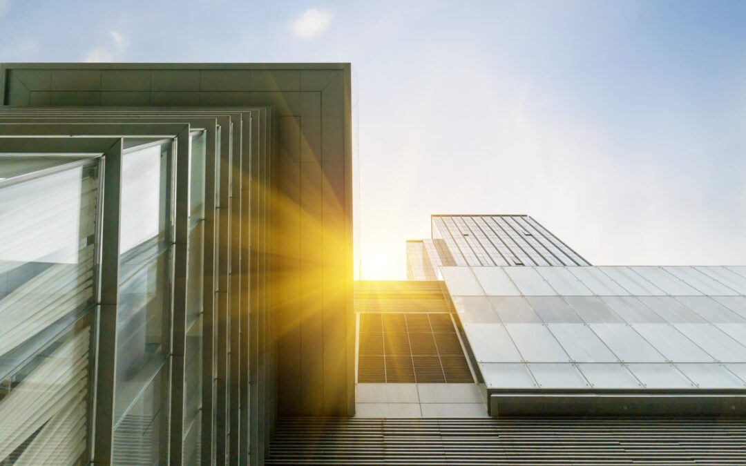 Looking up at a tall glass office building, the sun shows just slightly in the middle. For 2023, we predicted that community voice, impact measurement and competition for talent would be trends. But what did we miss?