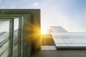 Looking up at a tall glass office building, the sun shows just slightly in the middle. For 2023, we predicted that community voice, impact measurement and competition for talent would be trends. But what did we miss?